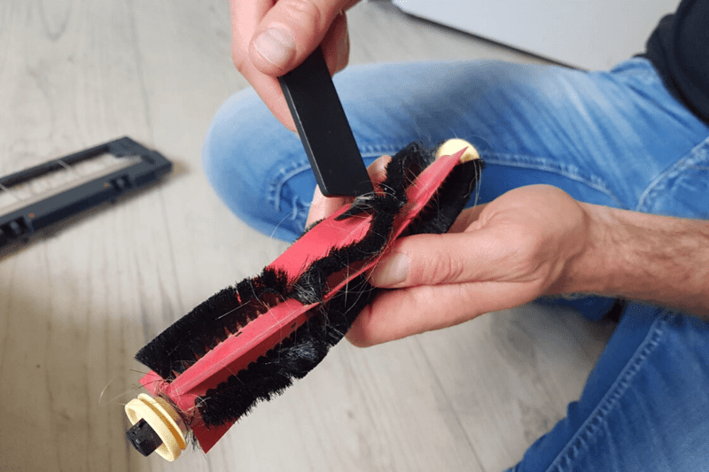 Волосы удаляются с щетки пылесоса Roborock с помощью чистящего инструмента